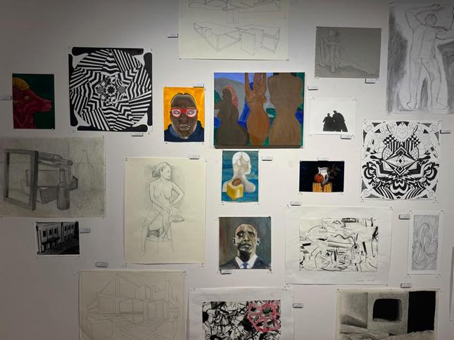 a collection of student pieces on the gallery wall